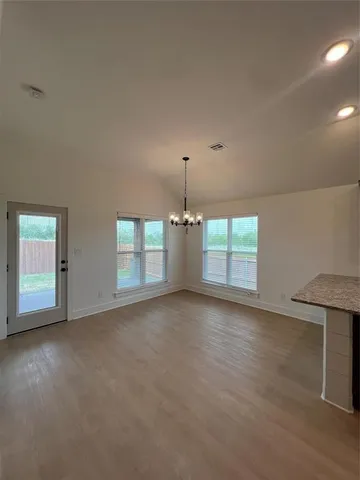 en empty room with windows and cabinet