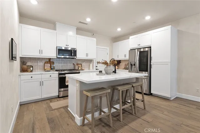 a kitchen with a sink a stove a refrigerator cabinets and a dining table