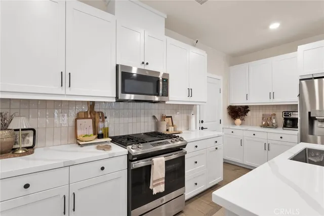 a kitchen with white cabinets stainless steel appliances and sink