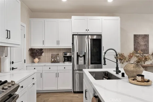 a kitchen with white cabinets and appliances