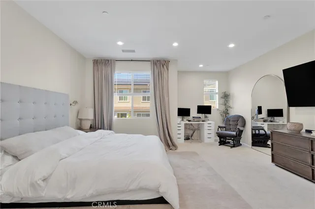 a large bedroom with a large bed and flat tv