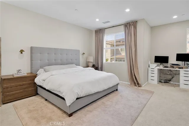 a spacious bedroom with a bed and a view of kitchen