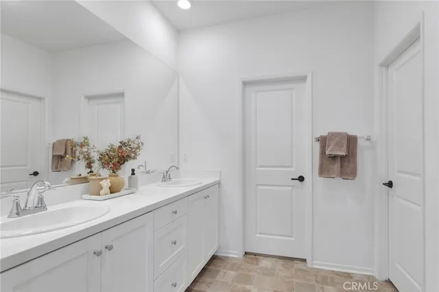 a bathroom with a double vanity sink and mirror