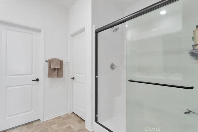 a bathroom with a shower and a glass door