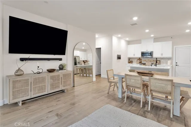 a kitchen with white cabinets and chairs