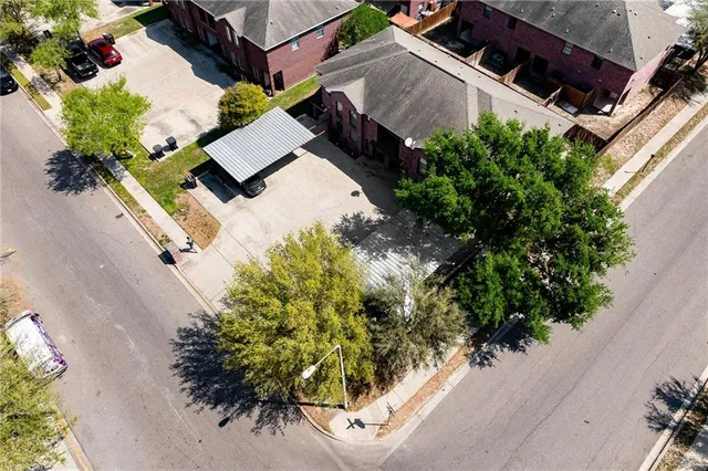 an aerial view of a house with a yard and large trees