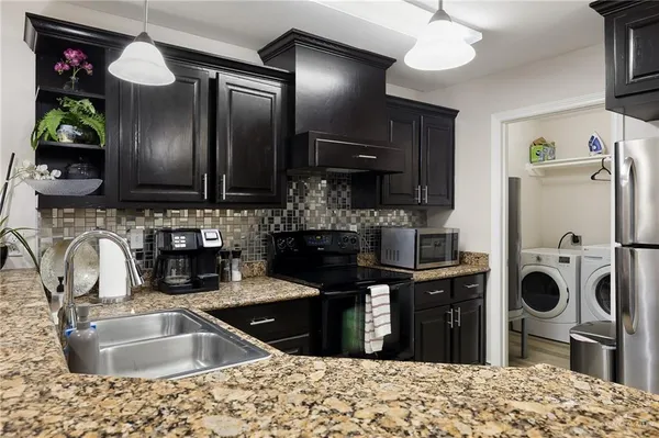 a kitchen with a stove a sink and cabinets
