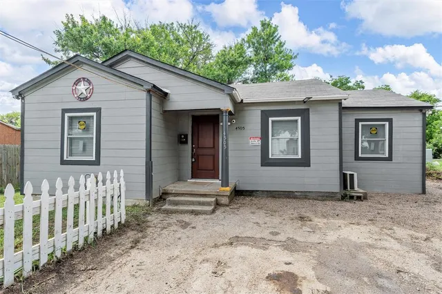 a view of a house with wooden fence