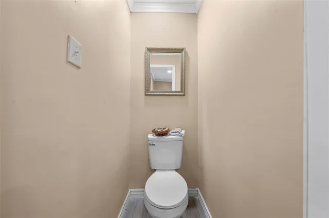 a white toilet sitting next to a white sink and a vanity