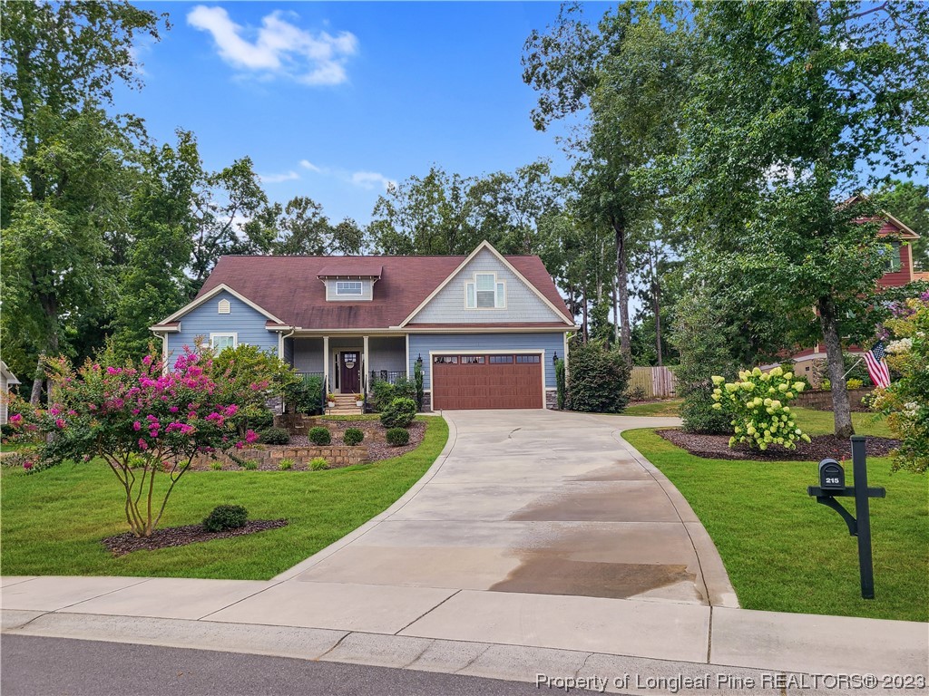 215 Devon Circle Aberdeen, NC 28315 - Photo 1 of 35 a front view of a house with a garden and plants