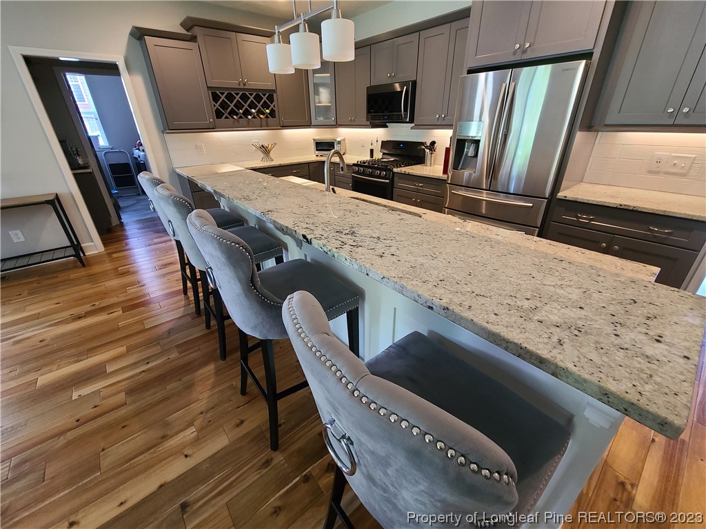 215 Devon Circle Aberdeen, NC 28315 - Photo 13 of 35 a kitchen with stainless steel appliances granite countertop a table chairs and a refrigerator