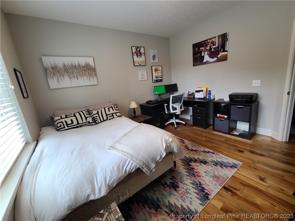 215 Devon Circle Aberdeen, NC 28315 - Photo 24 of 35 a bedroom with bed and wooden floor
