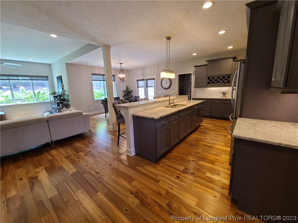 215 Devon Circle Aberdeen, NC 28315 - Photo 7 of 35 a large kitchen with stainless steel appliances granite countertop a stove and a wooden floors