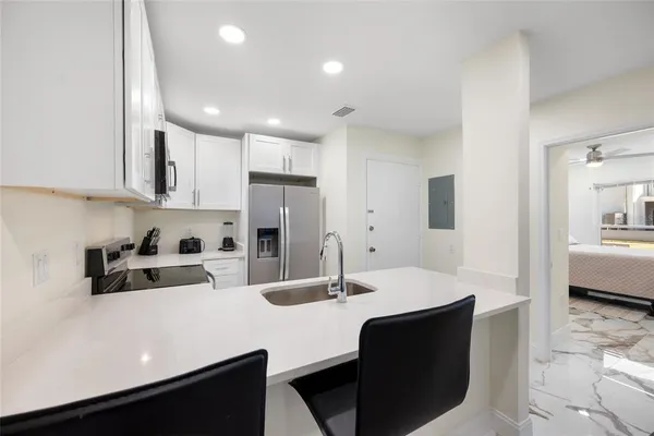 a kitchen with kitchen island a sink stove and refrigerator