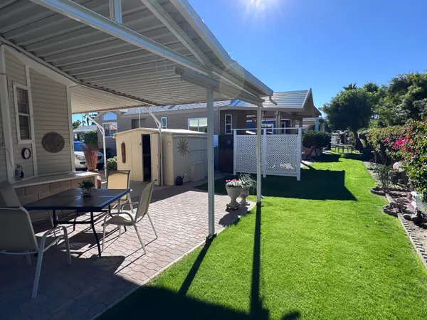 a view of a backyard with plants and patio