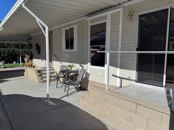 a patio with table and chairs and potted plants