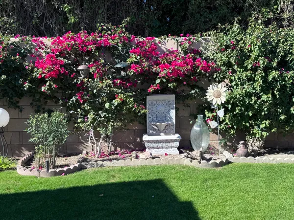 a front view of a house with a yard and fountain