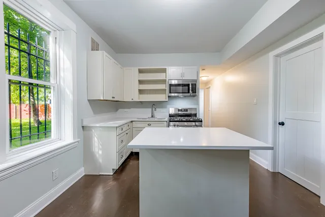 a kitchen with kitchen island a sink dishwasher a stove and a refrigerator with wooden floor