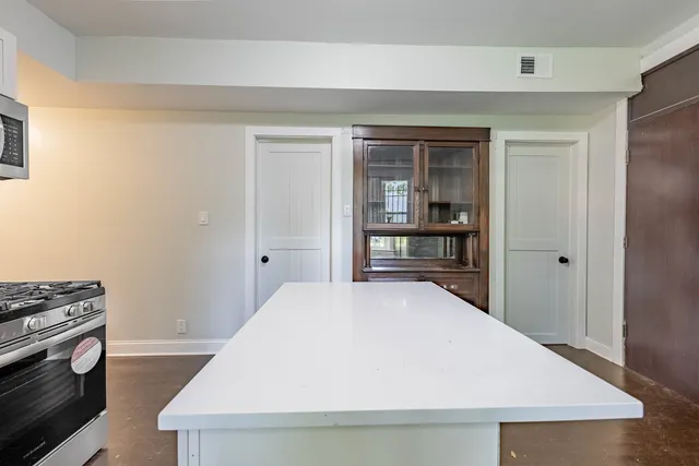 a kitchen with a wooden floor and a fireplace