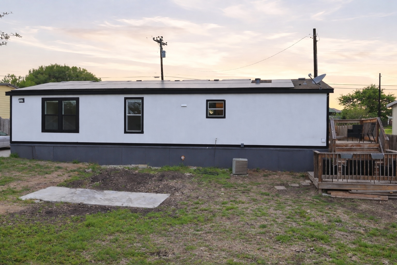 580 Railyard Drive Kyle, TX 78640 - Photo 20 of 20 The property features a white exterior with black trim, a flat roof, and a wooden deck