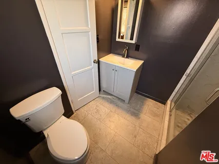 a bathroom with a toilet a sink and a mirror