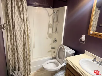 a white toilet sitting next to a bathroom sink and tub