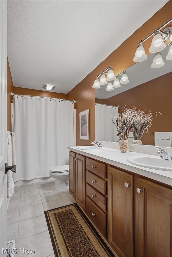 3955 Spring Brook Way Wooster, OH 44691 - Photo 23 of 50 Double vanity with integrated sinks, wood cabinetry with brushed nickel hardware, expansive mirror, tile flooring