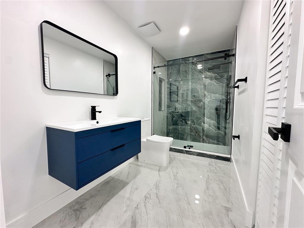 7984 Floral Drive Weeki Wachee, FL 34607 - Photo 17 of 31 a spacious bathroom with a mirror and a shower