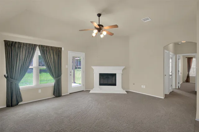 an empty room with windows and fan