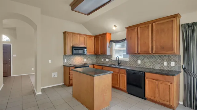a large kitchen with granite countertop a sink and a stove