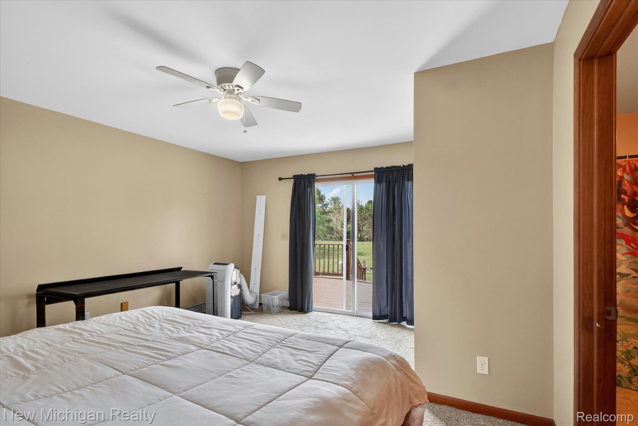 22623 11 Mile Road Reed City, MI 49677 - Photo 21 of 47 Spacious interior featuring a ceiling fan with integrated lighting, neutral wall tones, and carpet flooring