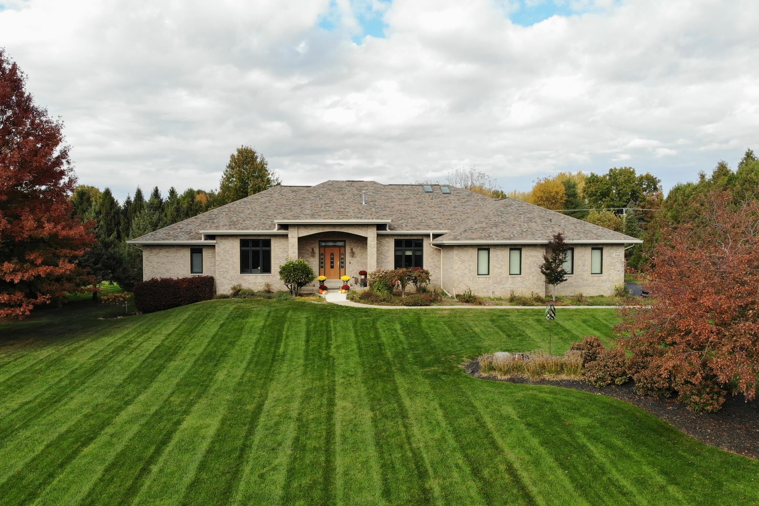 a front view of a house with yard patio and green space