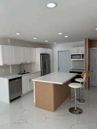 a kitchen with stainless steel appliances kitchen island granite countertop a sink and cabinets