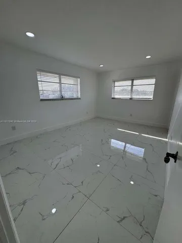 an empty room with windows and entrance