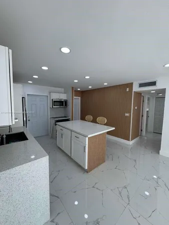 a kitchen with stainless steel appliances kitchen island granite countertop a table and chairs