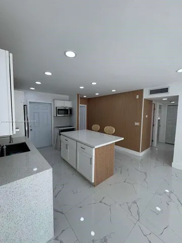 a kitchen with stainless steel appliances kitchen island granite countertop a table and chairs