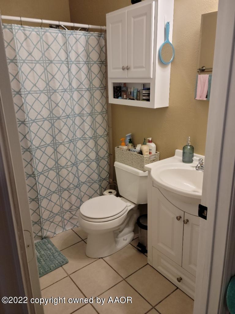 4434 South Travis Street Amarillo, TX 79110 - Photo 14 of 14 a bathroom with a sink a toilet and a mirror