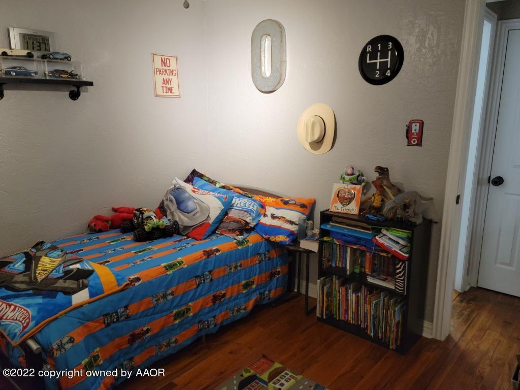 4434 South Travis Street Amarillo, TX 79110 - Photo 5 of 14 a bedroom with a bed and wooden floor
