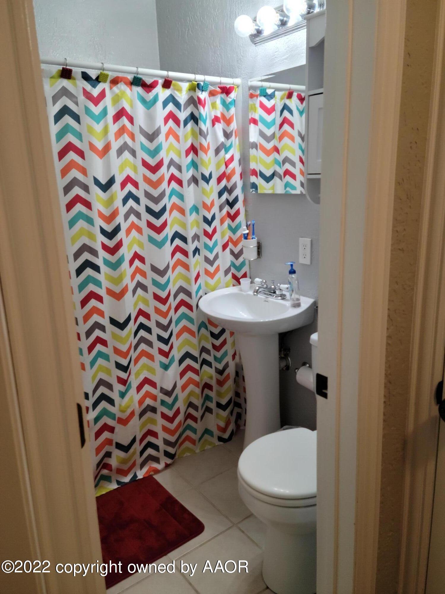 4434 South Travis Street Amarillo, TX 79110 - Photo 7 of 14 a bathroom with a sink toilet and a mirror