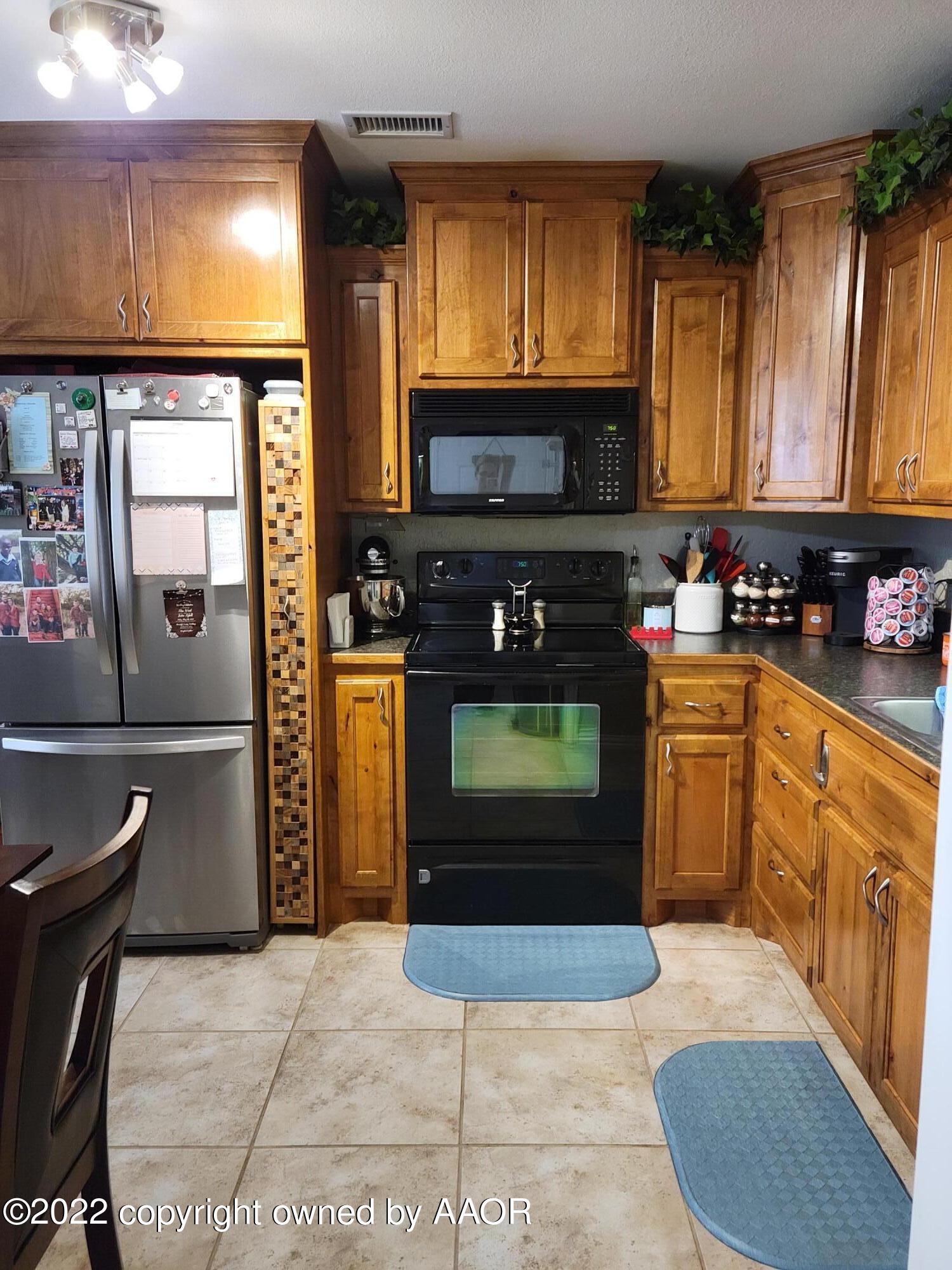 4434 South Travis Street Amarillo, TX 79110 - Photo 9 of 14 a kitchen with a stove a sink and a microwave
