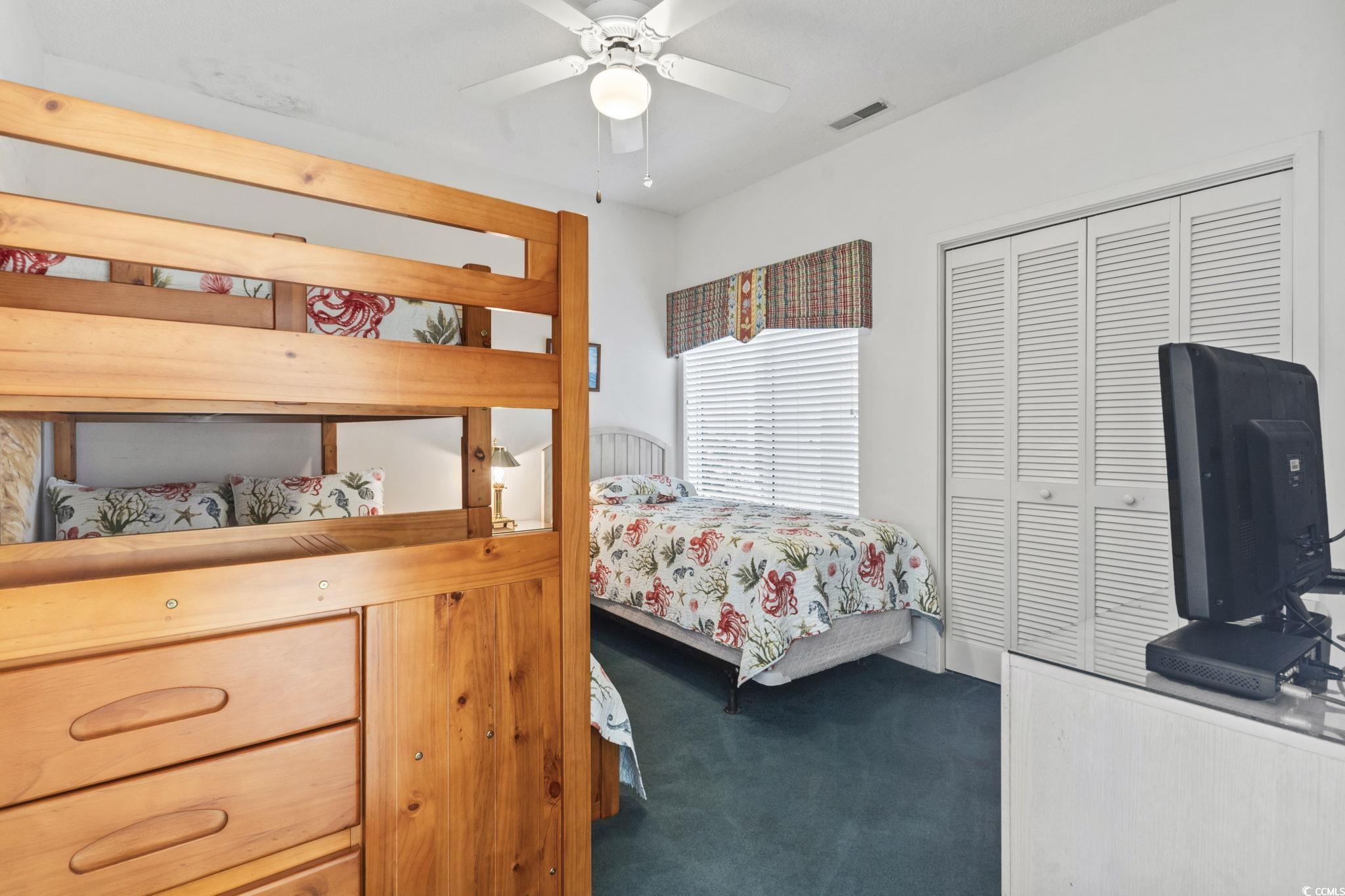 104 High Circle, Unit 8C Myrtle Beach, SC 29572 - Photo 14 of 36 Carpeted bedroom featuring ceiling fan and a closet