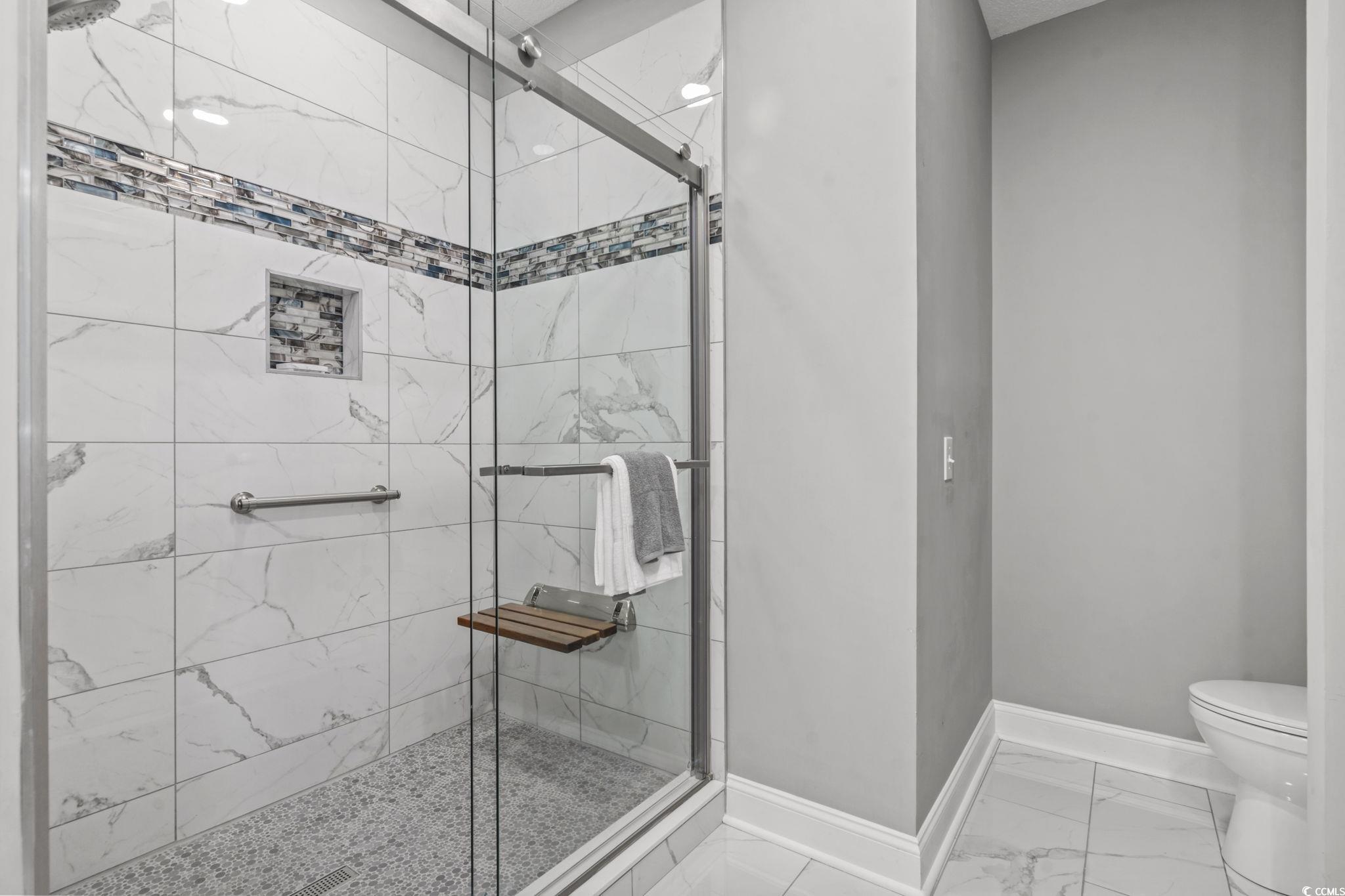 104 High Circle, Unit 8C Myrtle Beach, SC 29572 - Photo 19 of 36 Full bathroom featuring a shower stall and light marble finish flooring