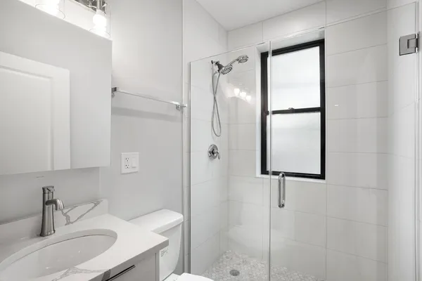 a bathroom with a shower sink and mirror