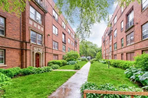 a view of a brick building next to a big yard