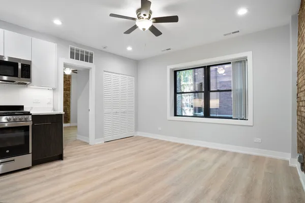 a view of an empty room with window and cabinet