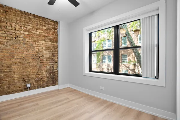 a view of an empty room with a window and a kitchen