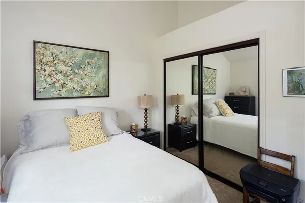 a bedroom with a bed and a painting on the wall