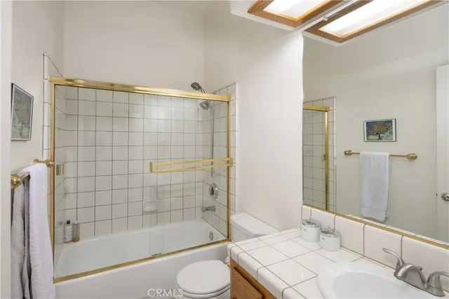 a bathroom with a bathtub shower sink vanity and toilet