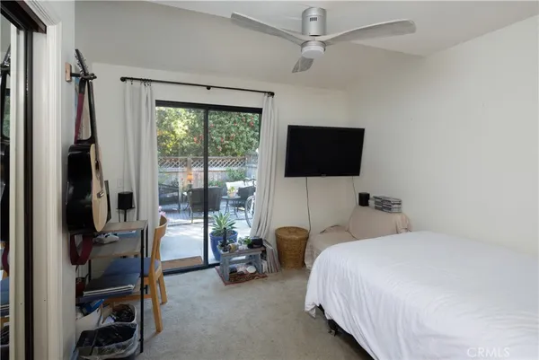 a bedroom with a bed and a flat tv screen on the dresser