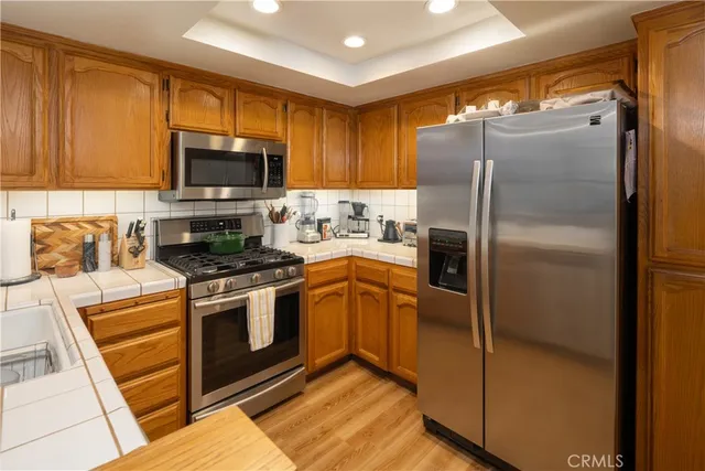 a kitchen with stainless steel appliances granite countertop a refrigerator a stove top oven a sink and dishwasher